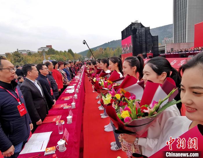图为青年学生在庆祝大会上为教师代表献花。　赵晓 摄